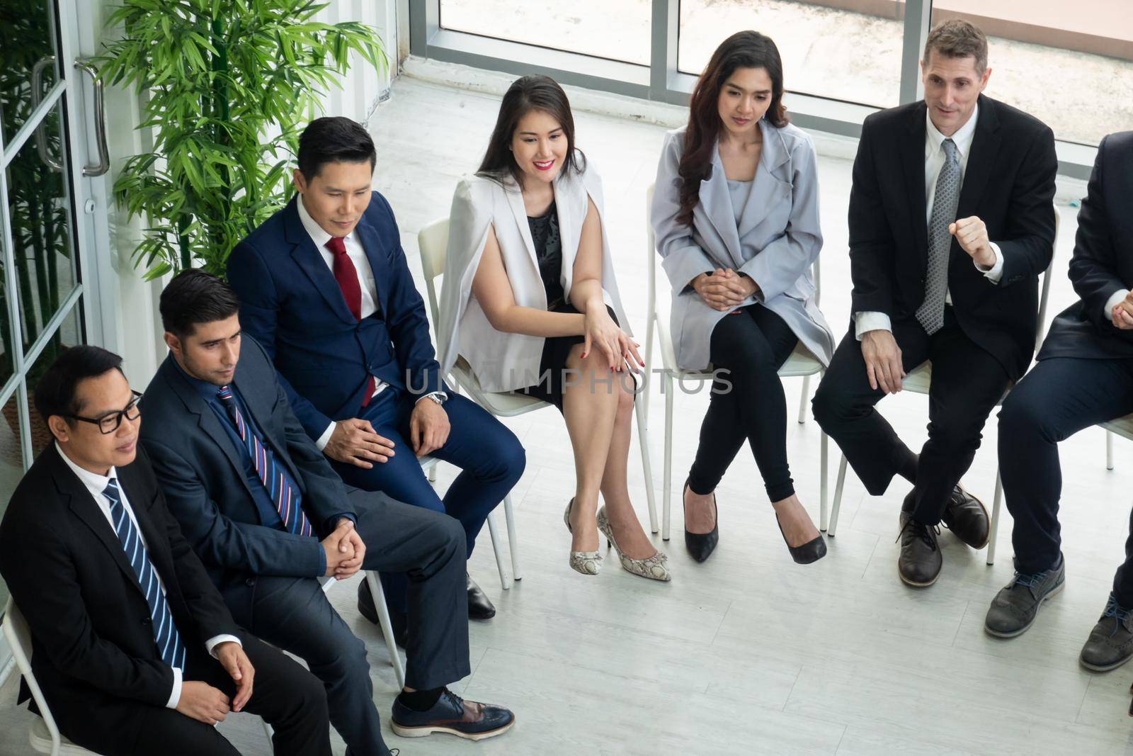 Shot of a group of businesspeople having a discussion in an office  by chuanchai