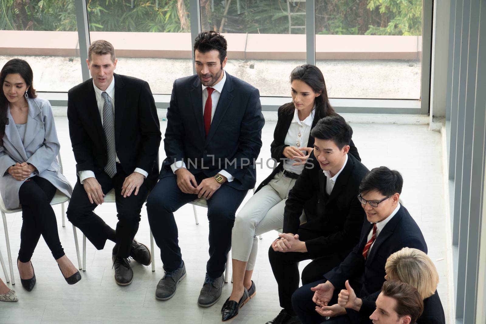 Shot of a group of businesspeople having a discussion in an office  by chuanchai