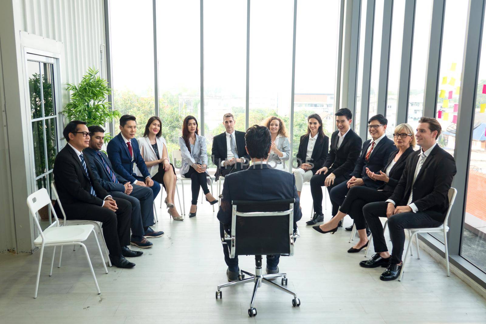 Shot of a group of businesspeople having a discussion in an office  by chuanchai