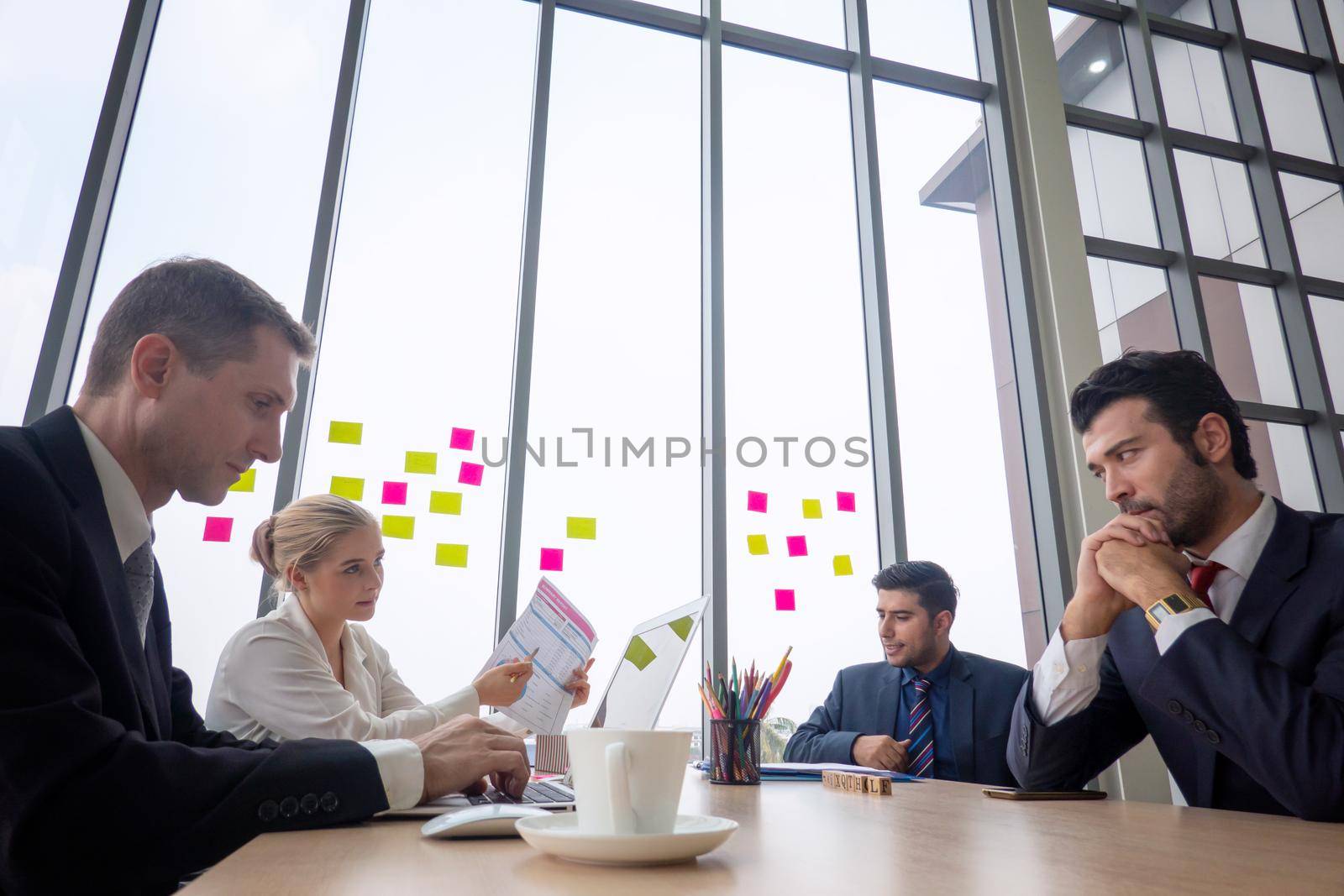 Shot of a group of businesspeople having a discussion in an office  by chuanchai