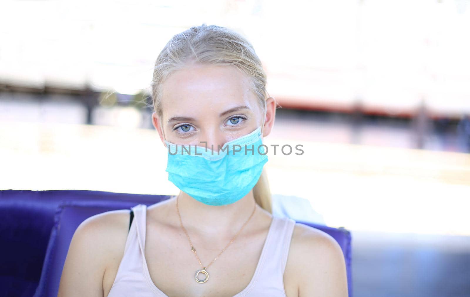 Portrait of confident young woman traveling by train, and wear protective face mask to prevent the spread of coronavirus, Covid-19 by chuanchai