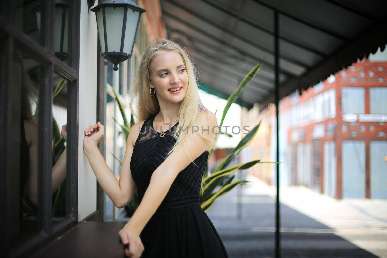 Portrait of Beautiful blonde hair girl on black dress as fashion portrait outdoor