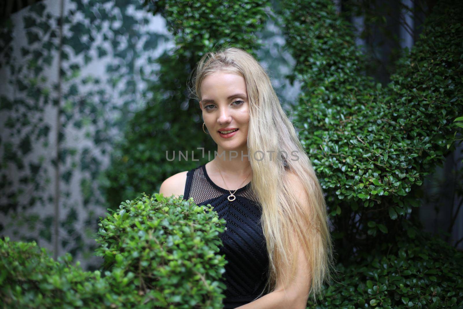 Portrait of Beautiful blonde hair girl on black dress as fashion portrait outdoor