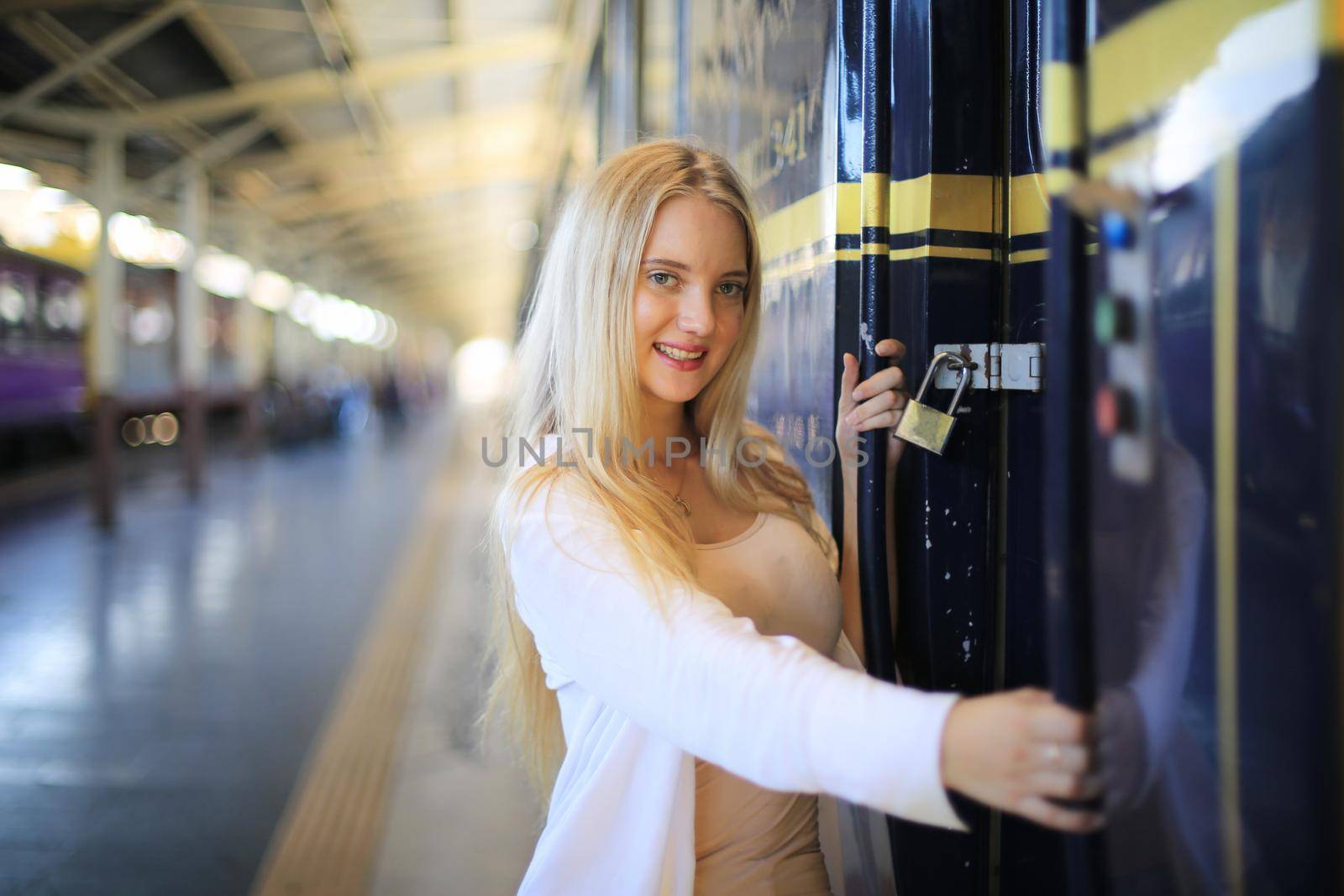 young woman waiting in vintage train, relaxed and carefree at the station platform in Bangkok, Thailand before catching a train. Travel photography. Lifestyle. by chuanchai