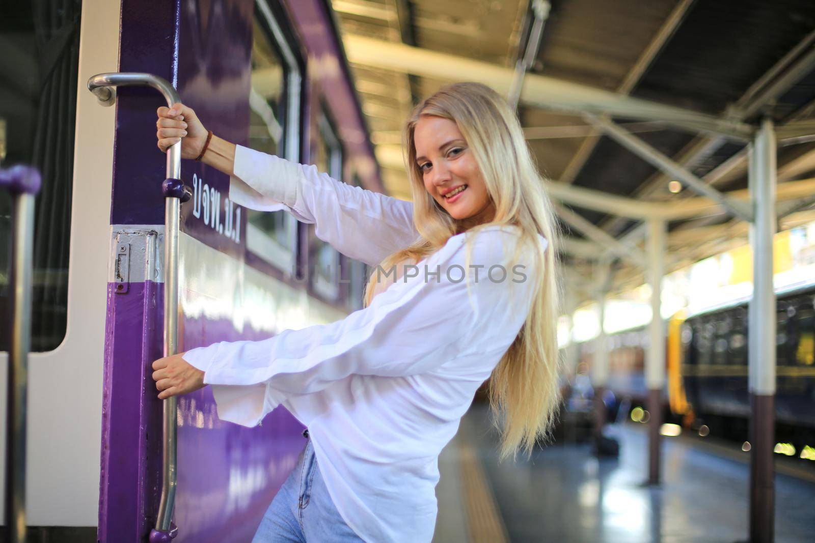 young woman waiting in vintage train, relaxed and carefree at the station platform in Bangkok, Thailand before catching a train. Travel photography. Lifestyle. by chuanchai