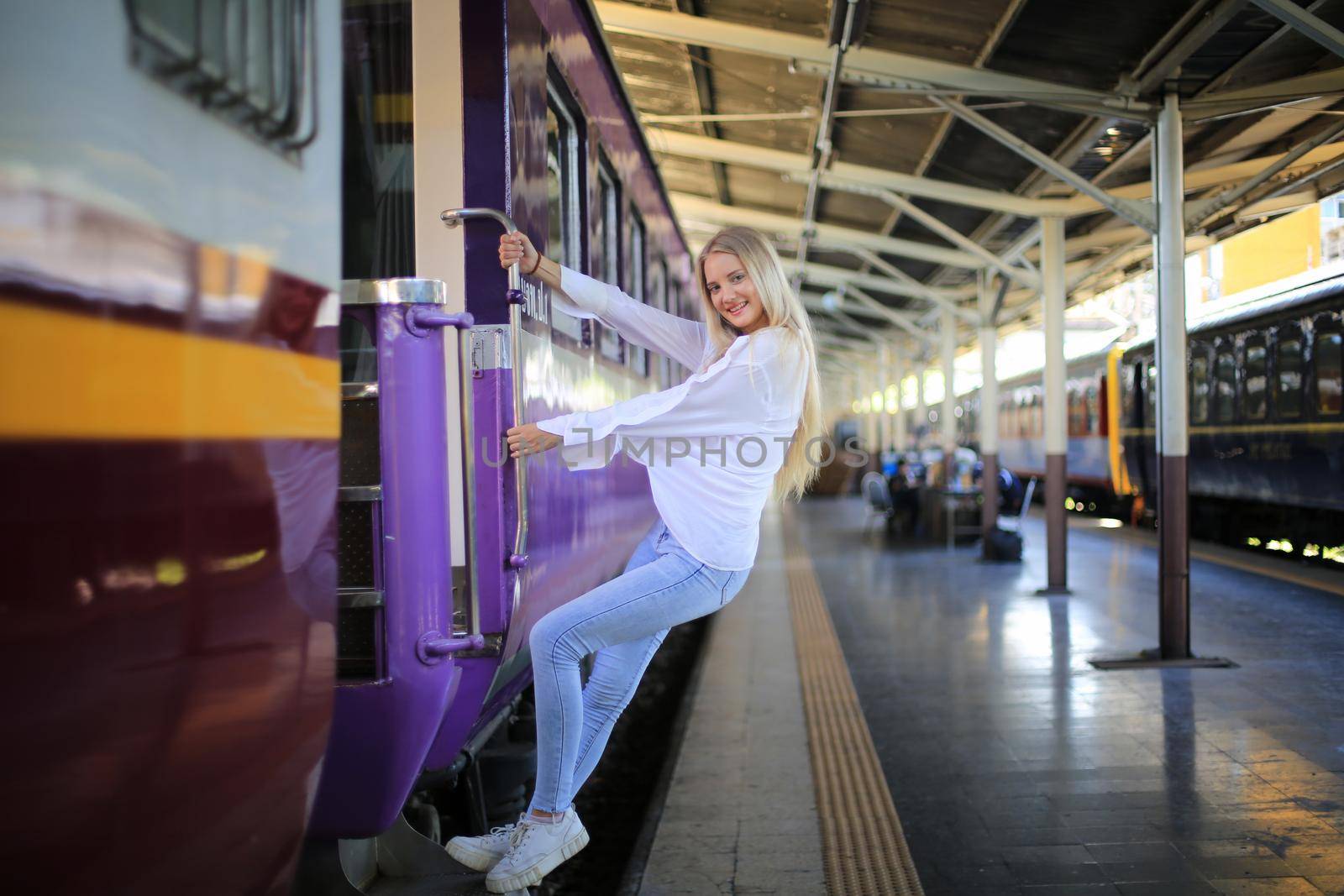 young woman waiting in vintage train, relaxed and carefree at the station platform in Bangkok, Thailand before catching a train. Travel photography. Lifestyle. by chuanchai