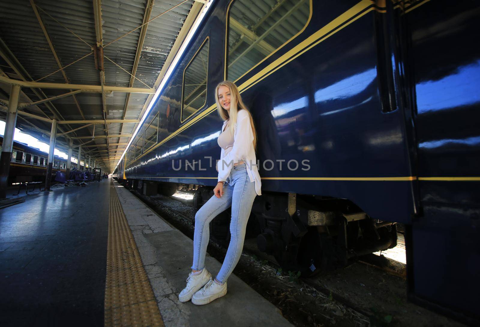 young woman waiting in vintage train, relaxed and carefree at the station platform in Bangkok, Thailand before catching a train. Travel photography. Lifestyle. by chuanchai