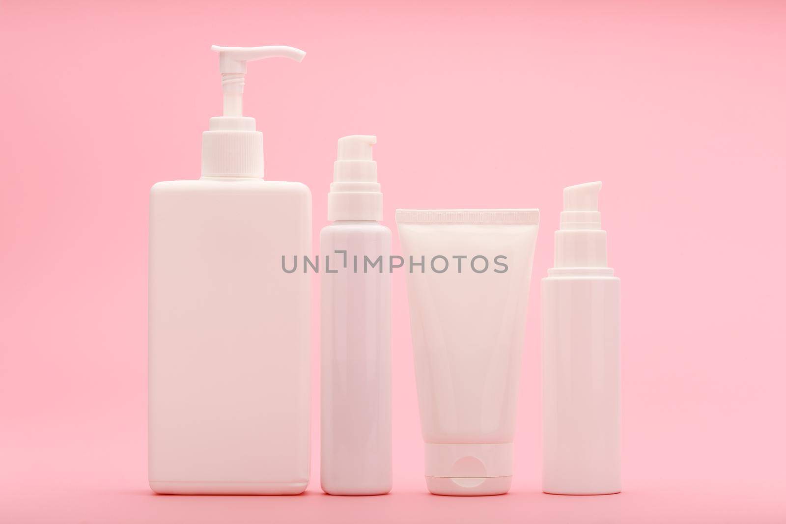Set of beauty products for daily anti acne skin treatment against light pink background. Concept of beauty products for regular face and bode care