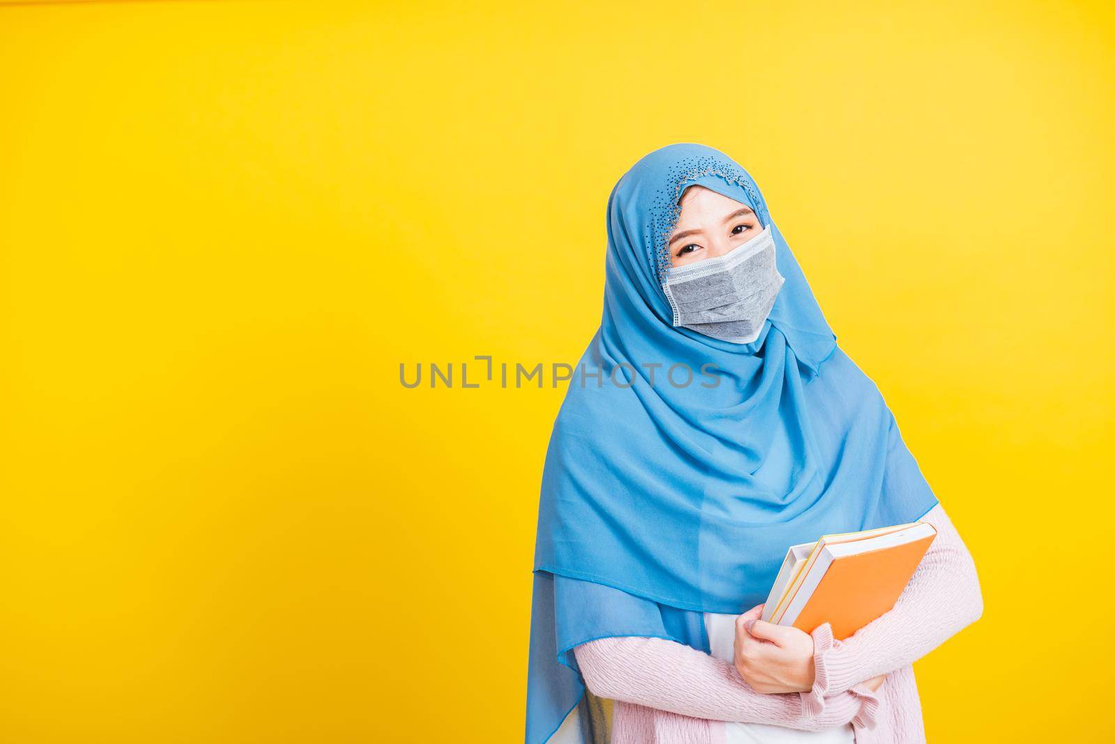 Woman religious wear veil hijab and face mask protective to prevent coronavirus she student hold books on hand by Sorapop