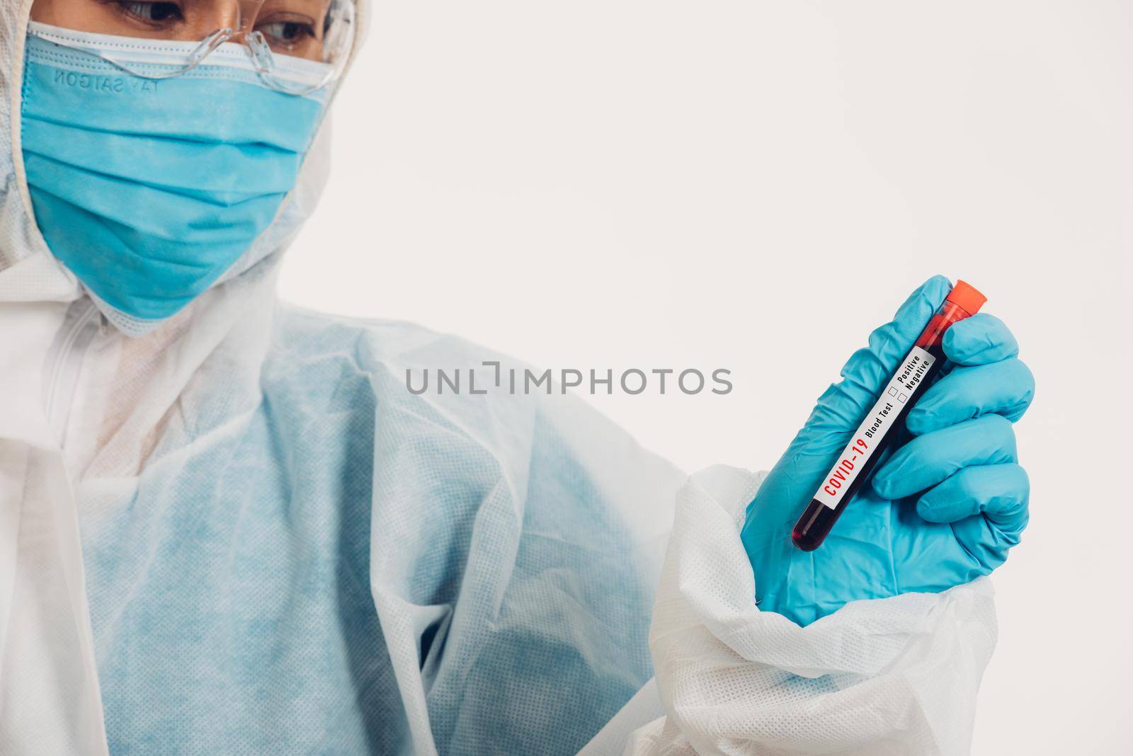 Medical scientist in PPE uniform wear a mask holding test tube Coronavirus test blood sample in a hospital laboratory for analyzing isolated on white, medicine COVID-19 pandemic outbreak concept