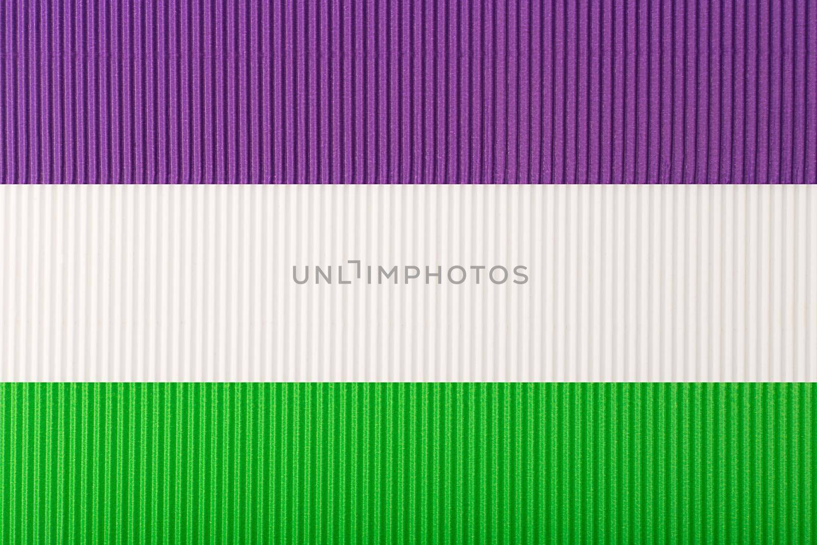 Official Genderqueer flag made of purple, white and green corrugated paper. Concept of genderqueer pride, agenderness, tolerance and respect for sexual minorities