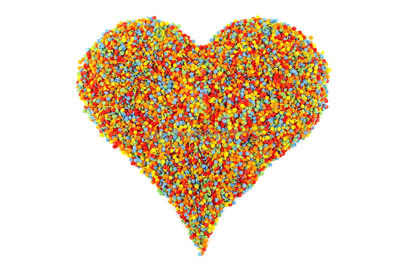 Colored sugar sprinkle dots laid in heart shape isolated on white background