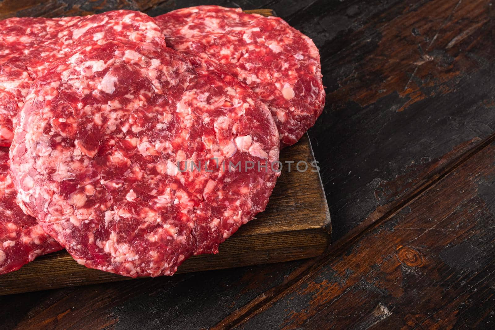 Ground Beef Patties for Grilling and Roasting set, on old dark wooden table background, with copy space for text