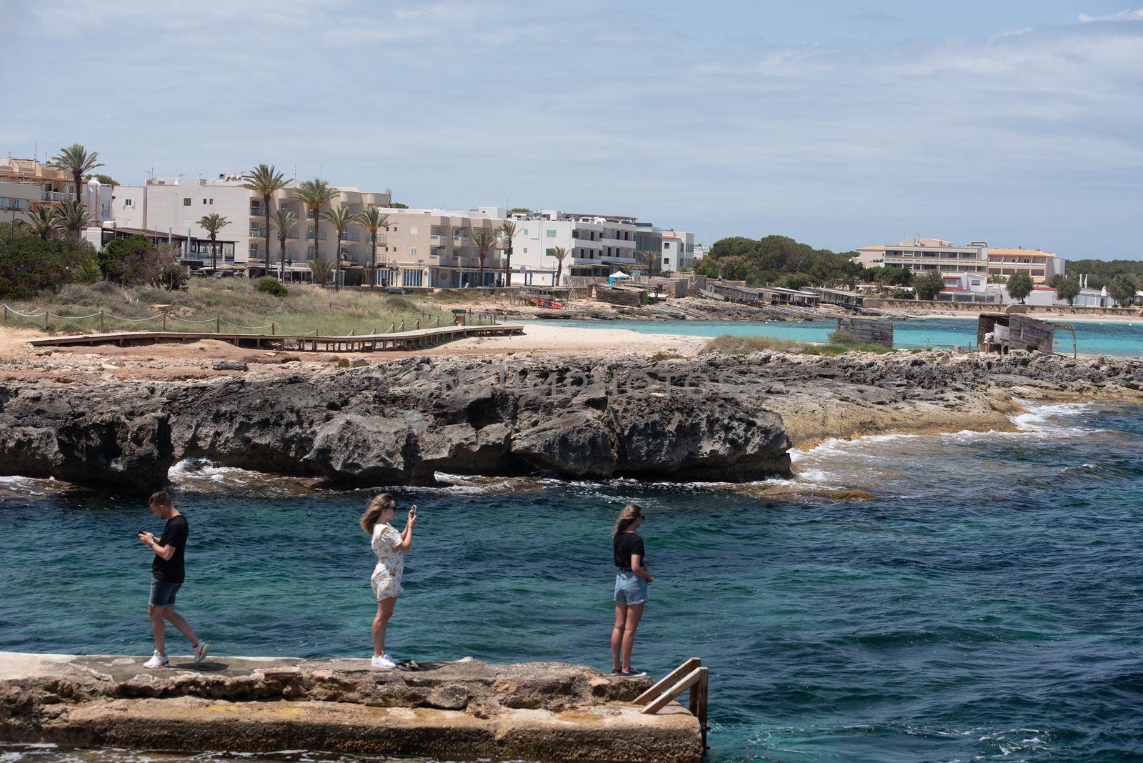 Formentera, Spain: 2021 May 29: Young people taking photos at Es Pujols beach in Formentera in the summer of 2021