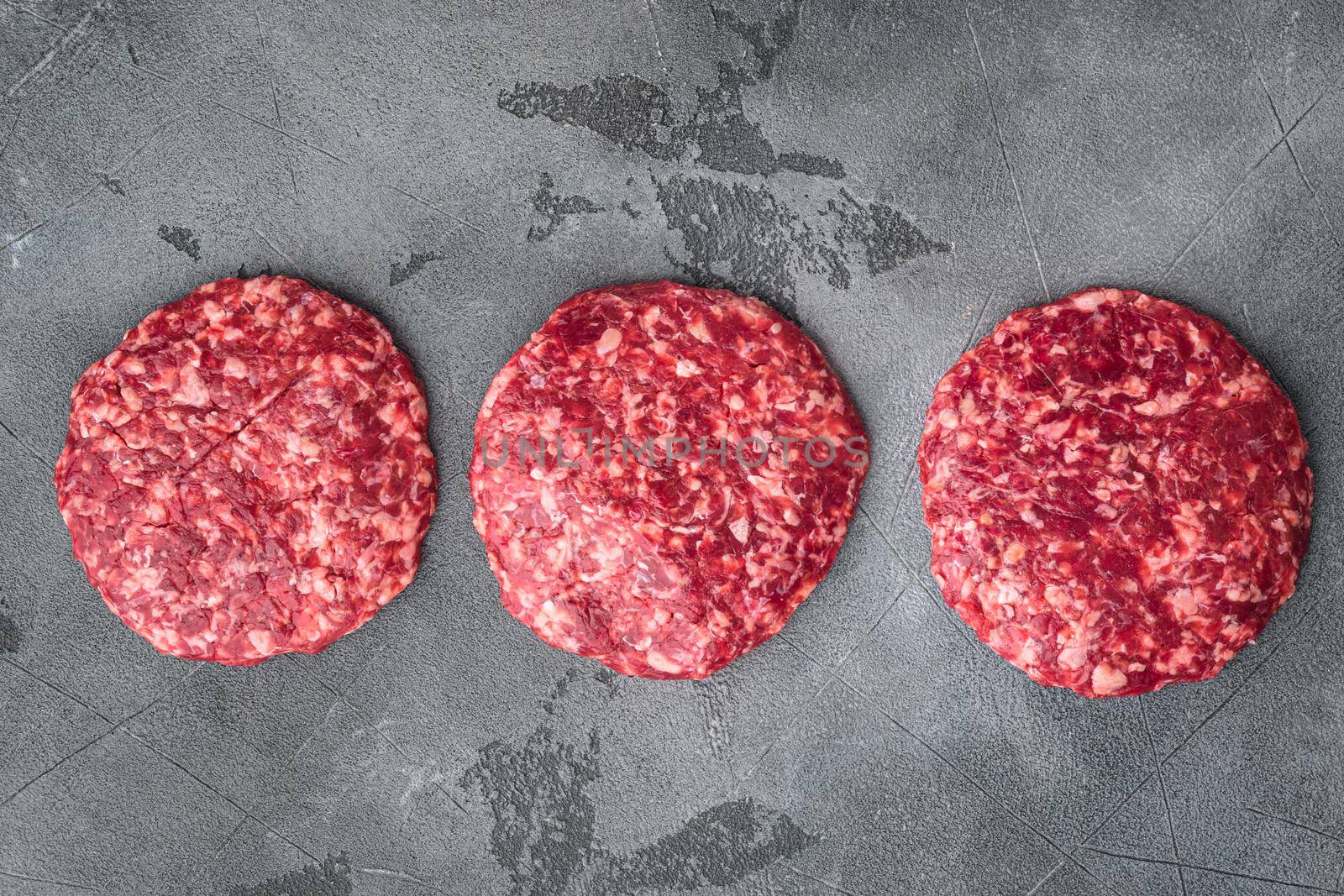 Raw Ground beef meat Burger steak cutlets set, on gray stone background, top view flat lay, with copy space for text