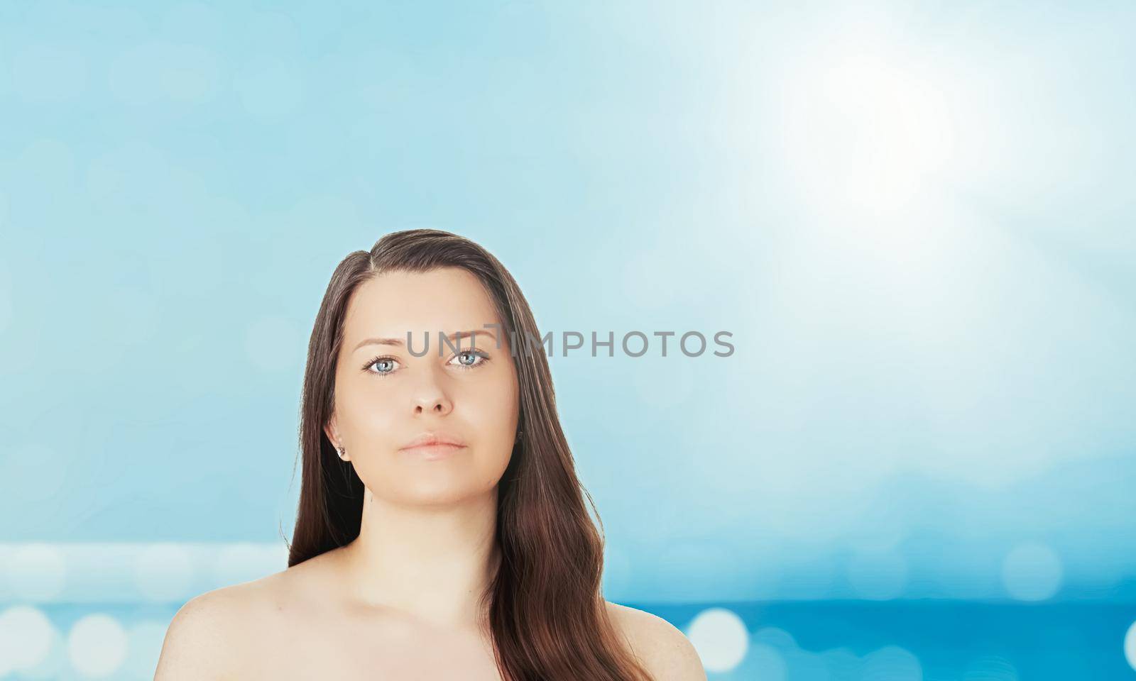 Skincare and sun protection in summer. Portrait of a beautiful young suntanned woman, blue sea and sky on background, beauty, wellness and travel concept.