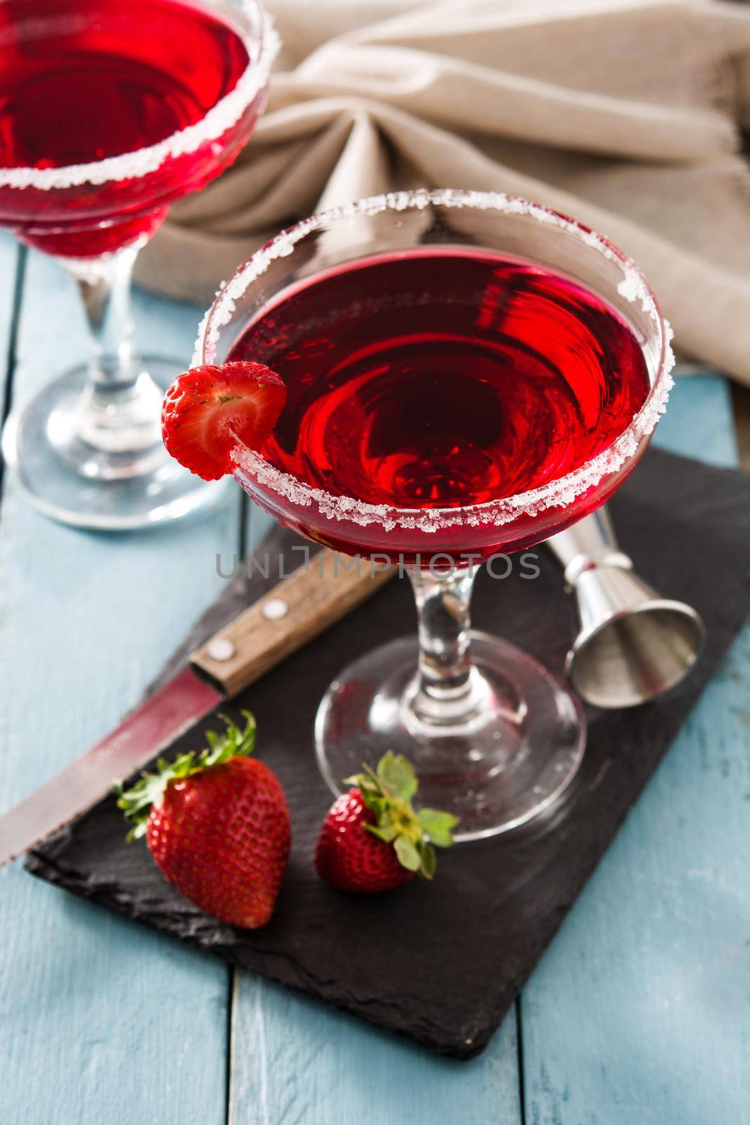 Strawberry cocktail drink in glass on blue wooden table