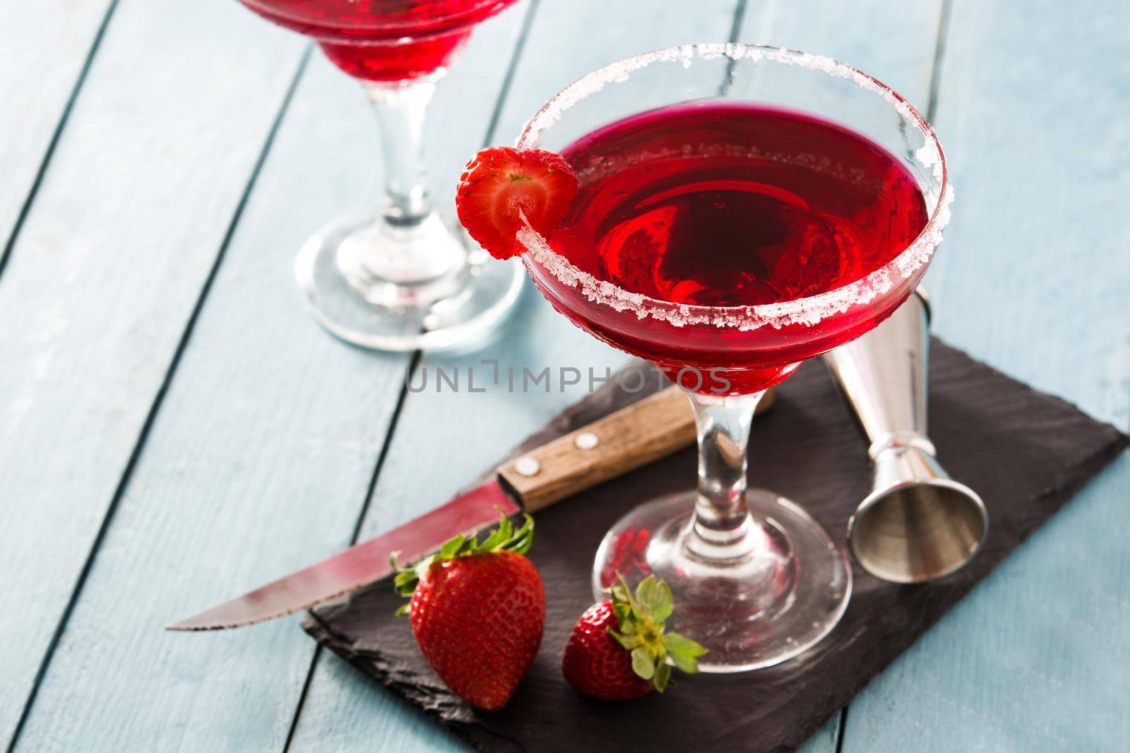 Strawberry cocktail drink in glass on blue wooden table