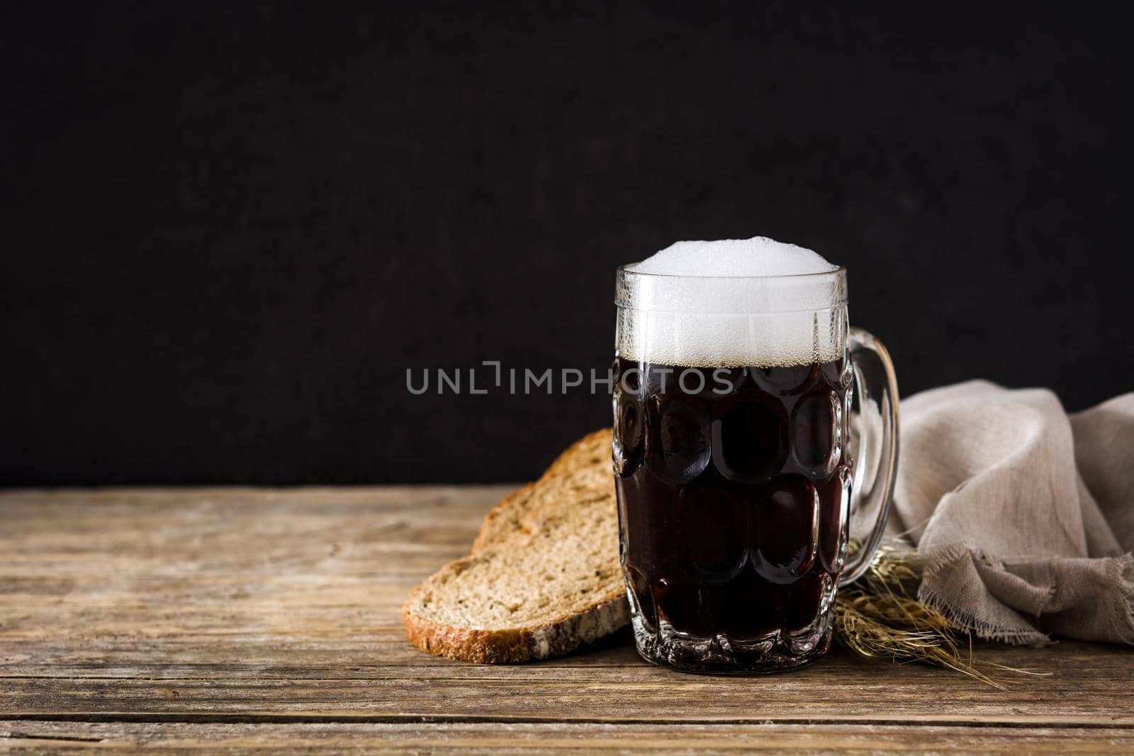 Traditional kvass beer mug with rye bread on wooden table