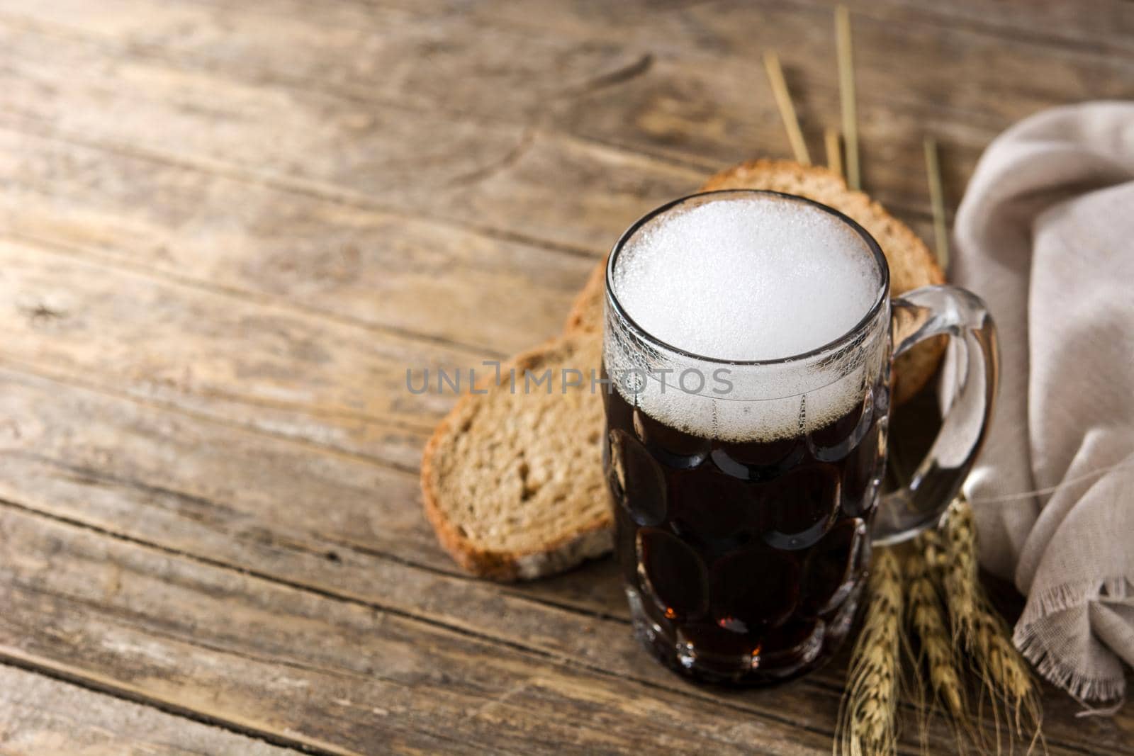 Traditional kvass beer mug with rye bread on wooden table