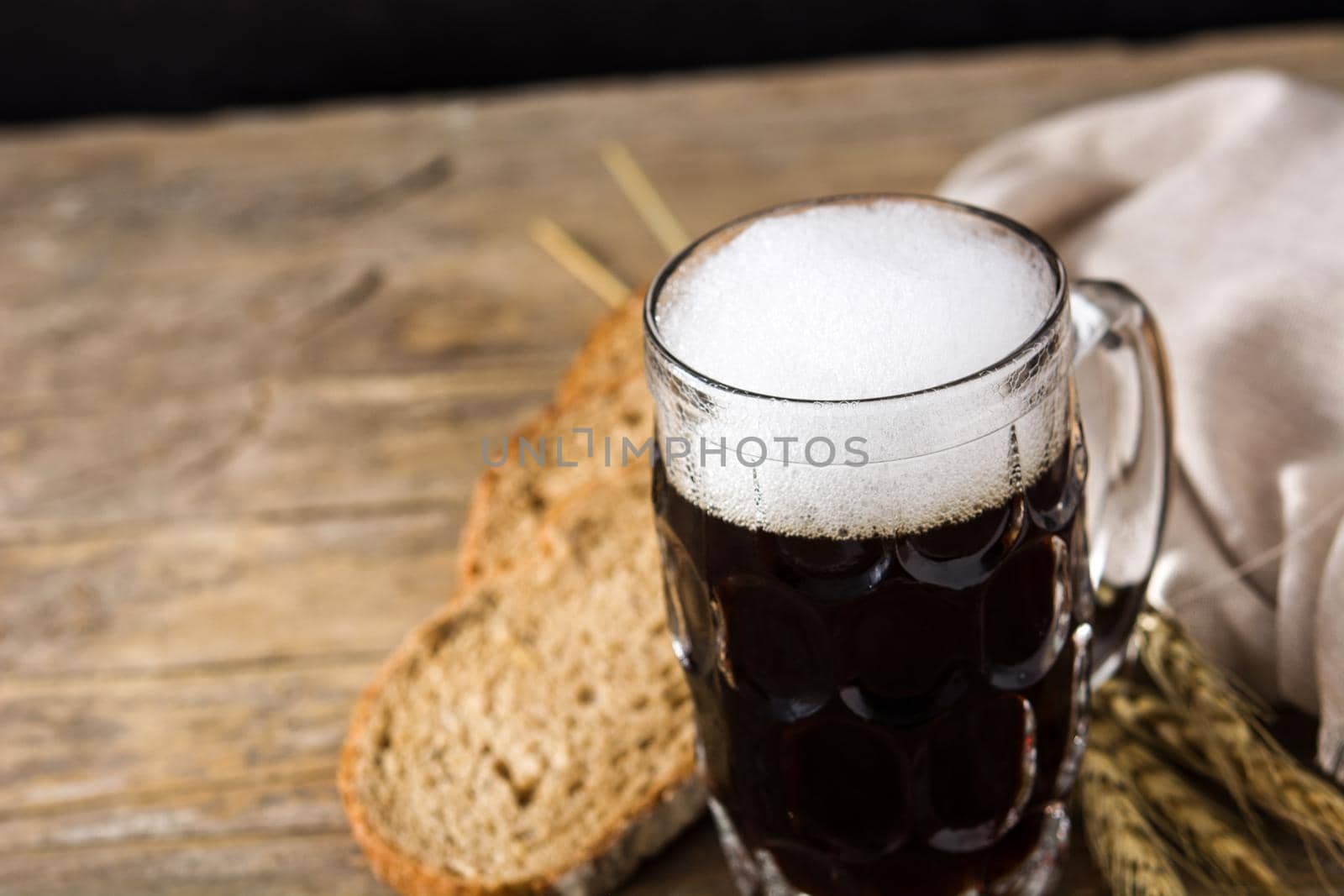 Traditional kvass beer mug with rye bread on wooden table