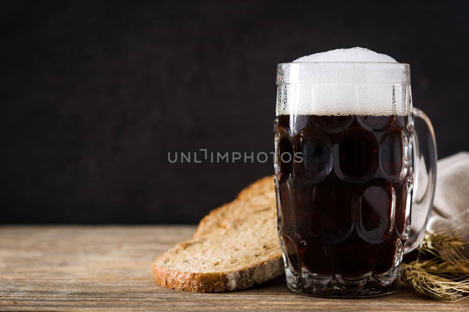 Traditional kvass beer mug with rye bread on wooden table