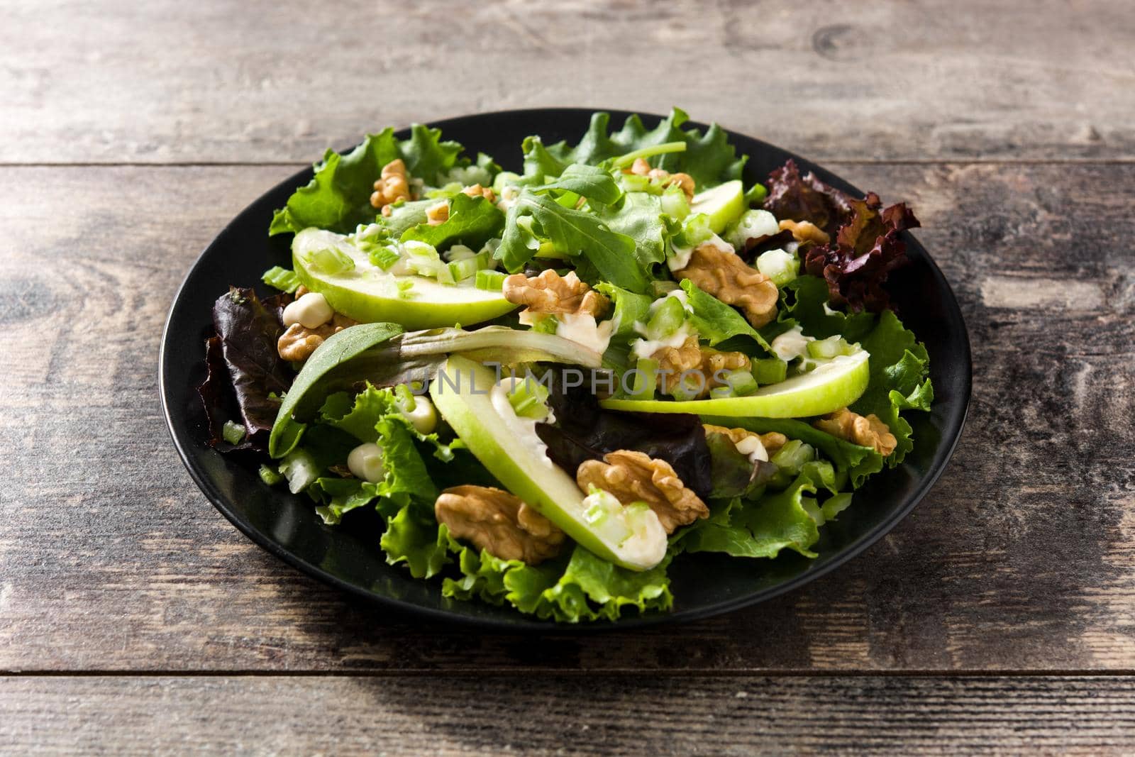 Fresh Waldorf salad with lettuce, green apples, walnuts and celery isolated on whtie background