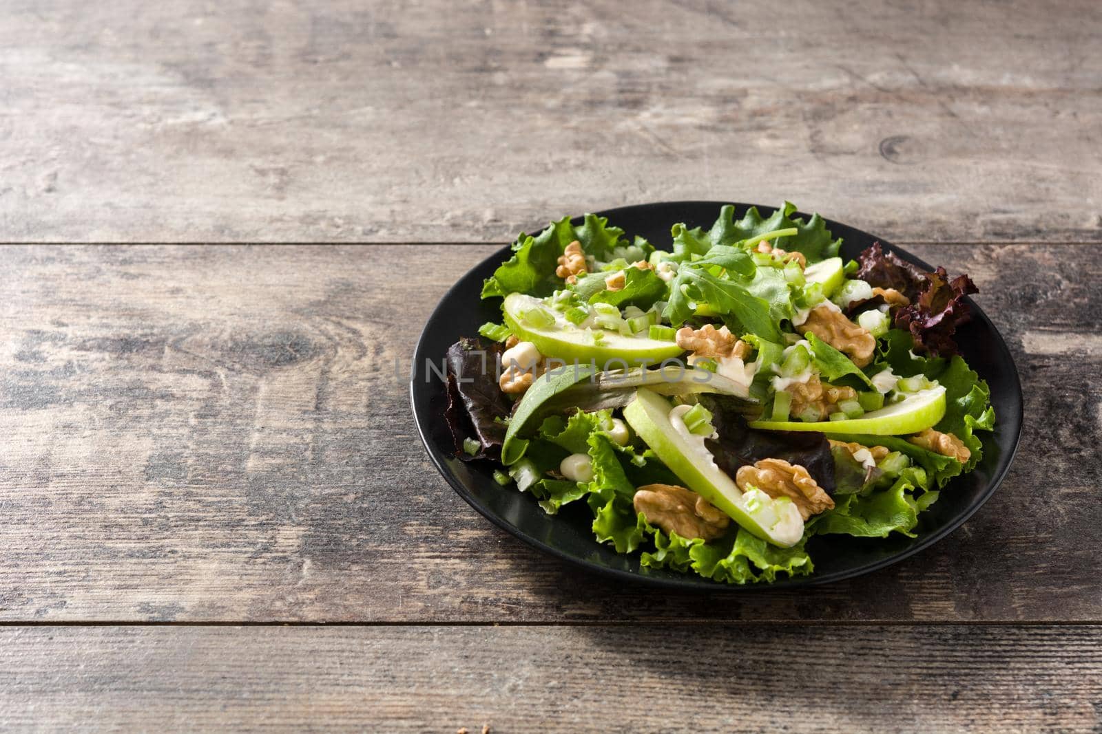 Fresh Waldorf salad with lettuce, green apples, walnuts and celery isolated on whtie background