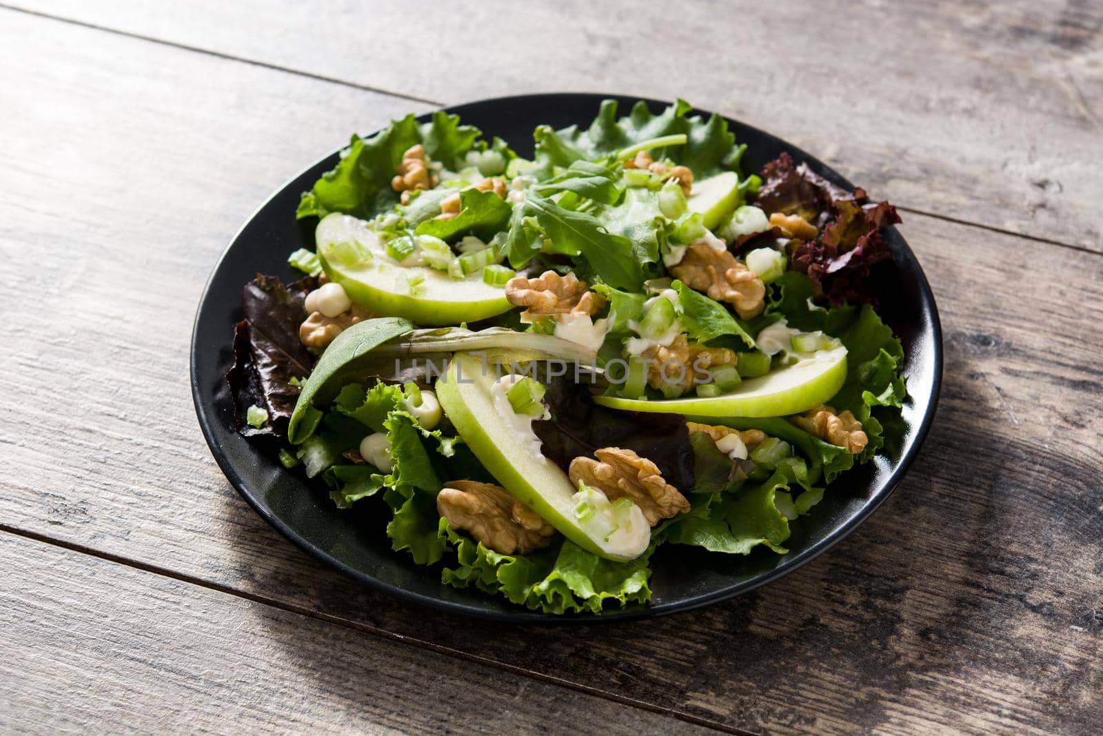 Fresh Waldorf salad with lettuce, green apples, walnuts and cele by chandlervid85