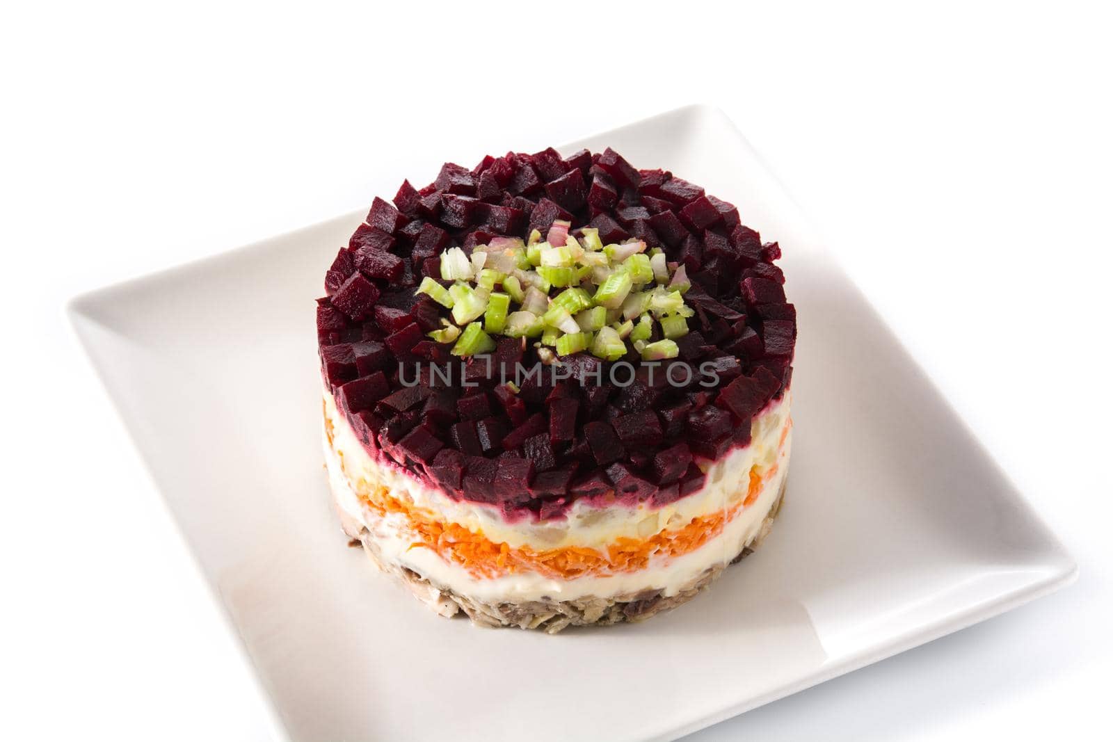 Traditional Russian herring salad with beetroot and carrots isolated on white background.