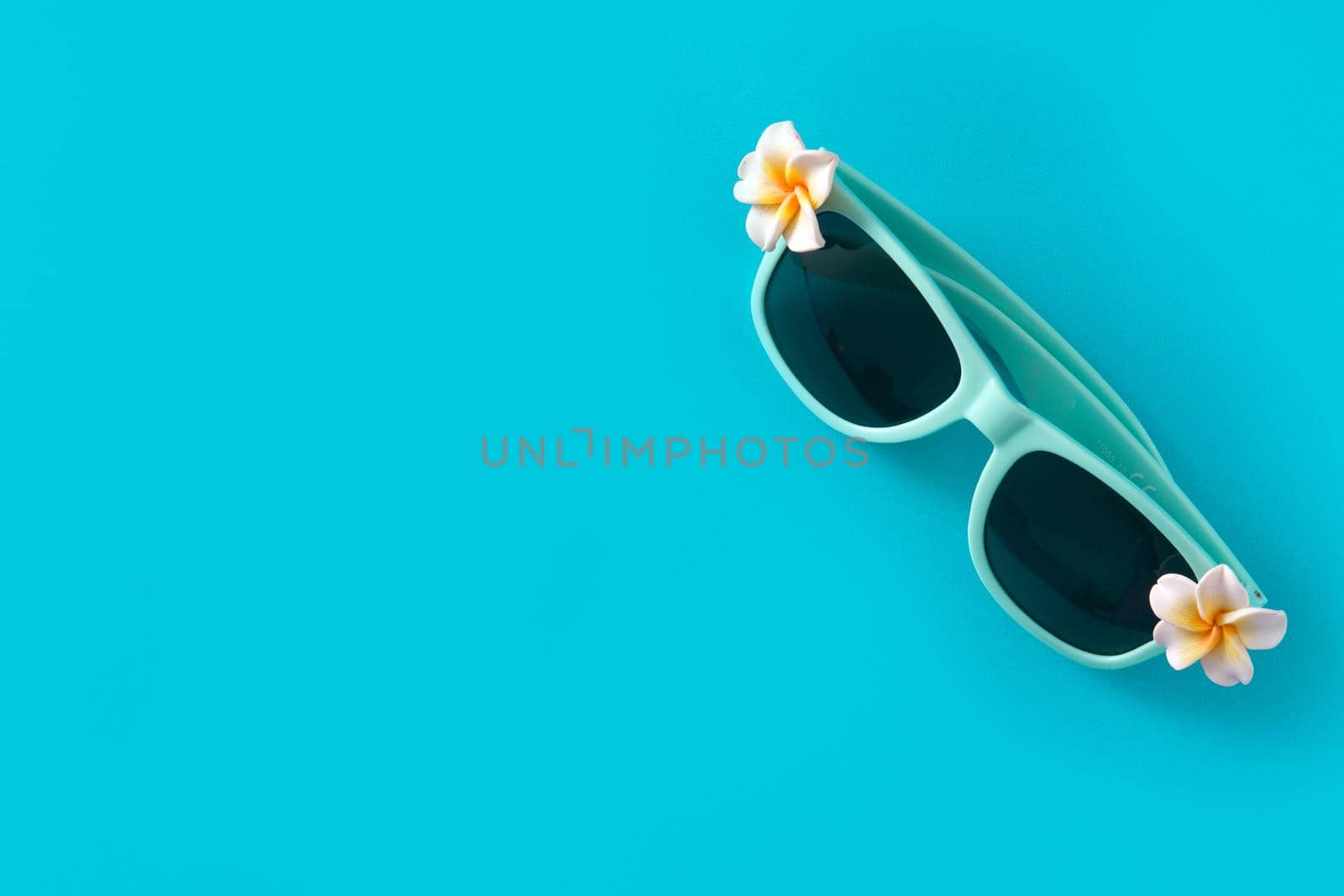 Sunglasses with flowers on blue background