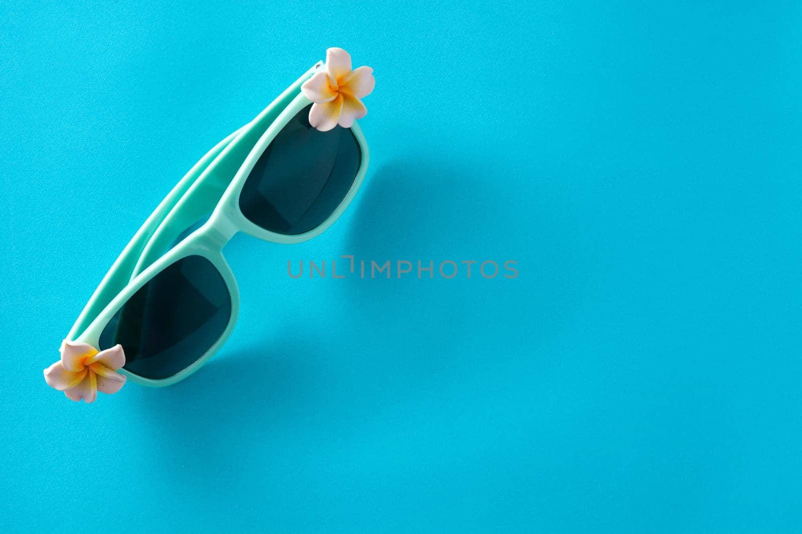 Sunglasses with flowers on blue background