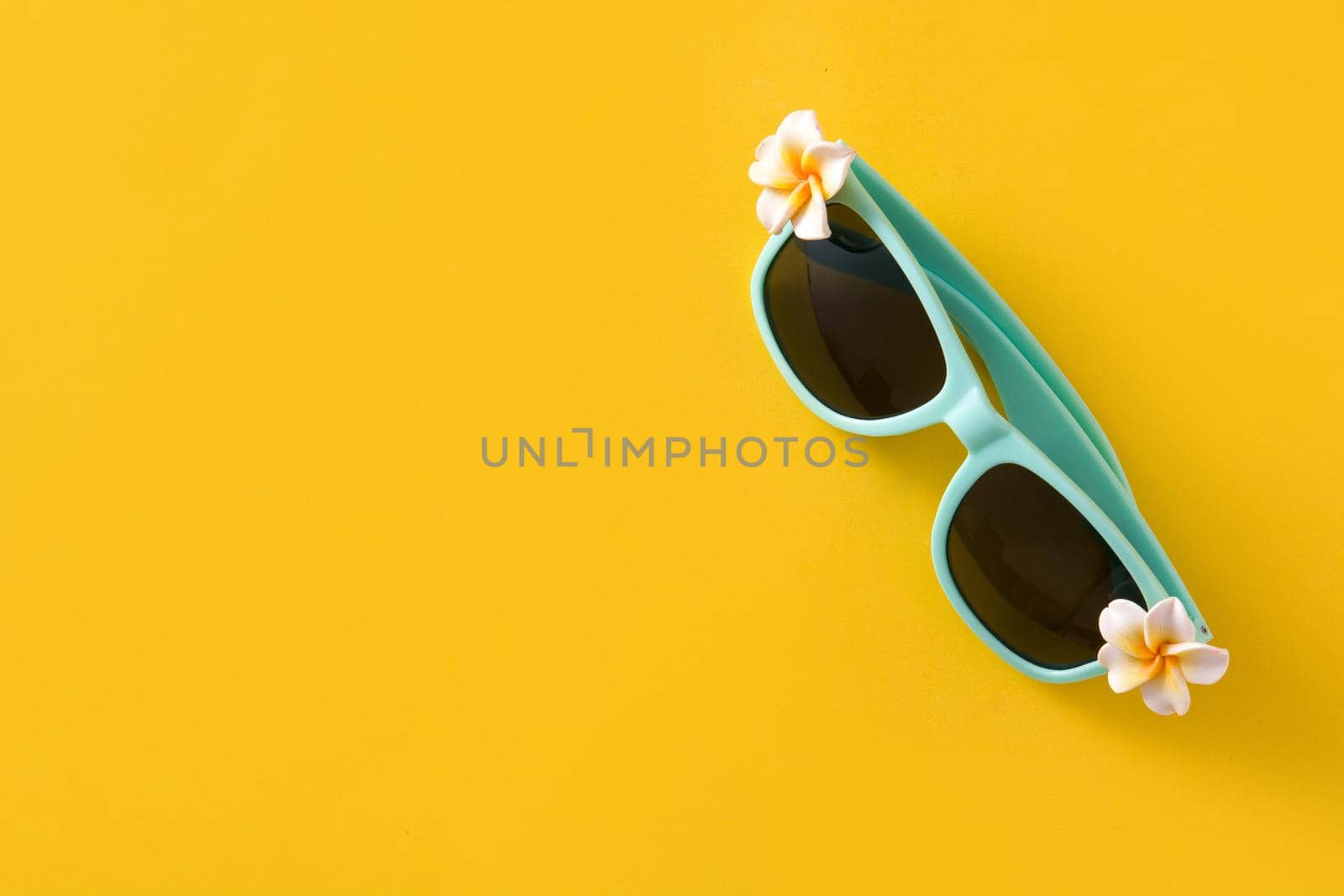 Sunglasses with flowers on yellow background