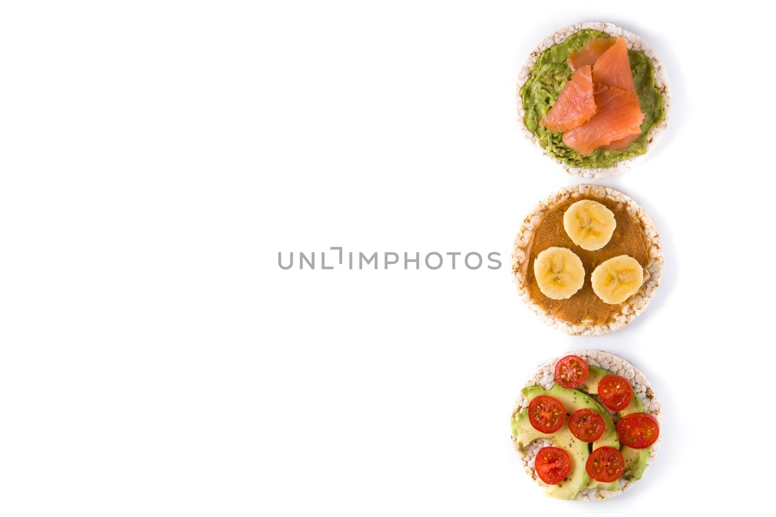 Puffed rice cakes with guacamole salmon,tomato and avocado, and banana with peanut butter isolated on white background
