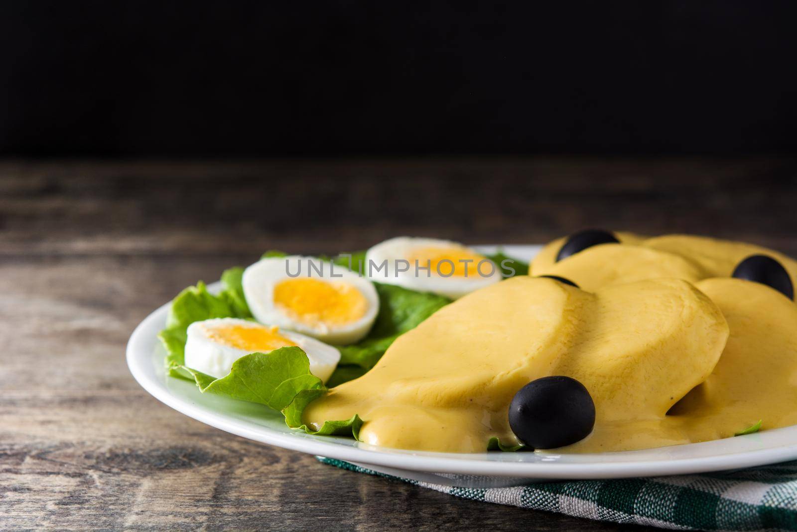 Traditional Peruvian papa a la huancaina on wooden table