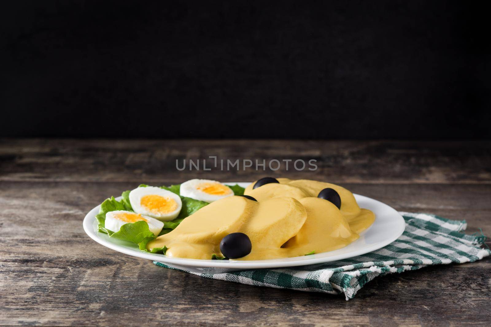 Traditional Peruvian papa a la huancaina on wooden table