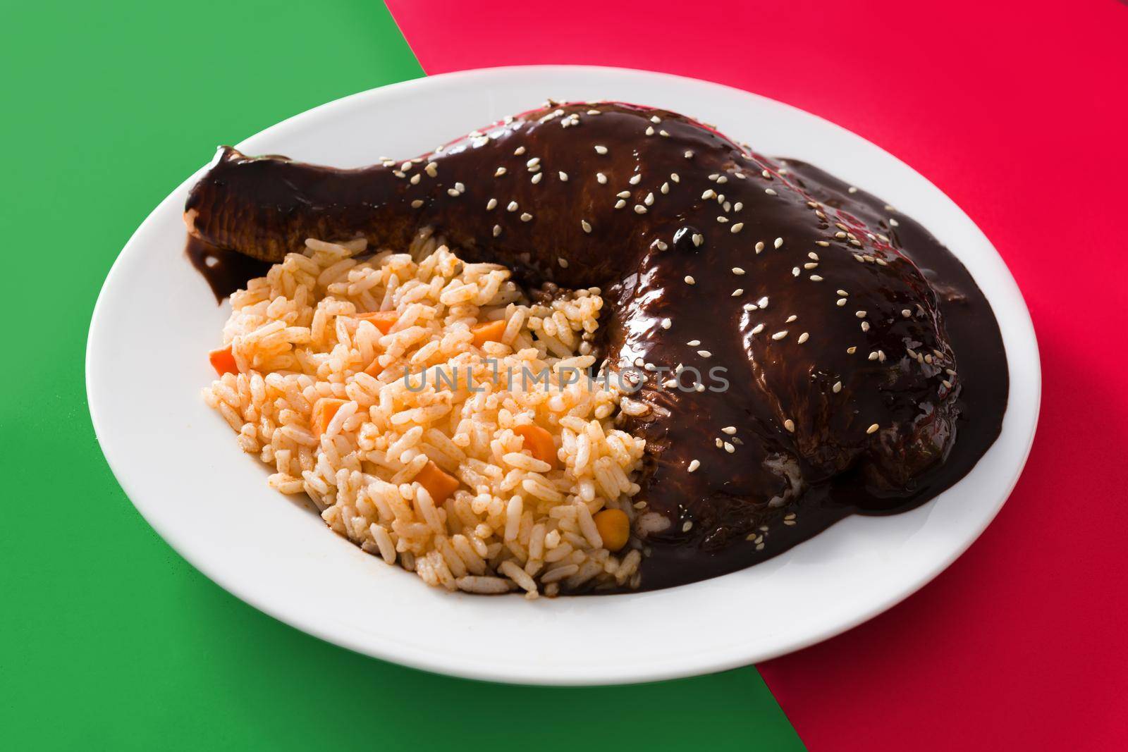 Traditional mole Poblano with rice on red and green background