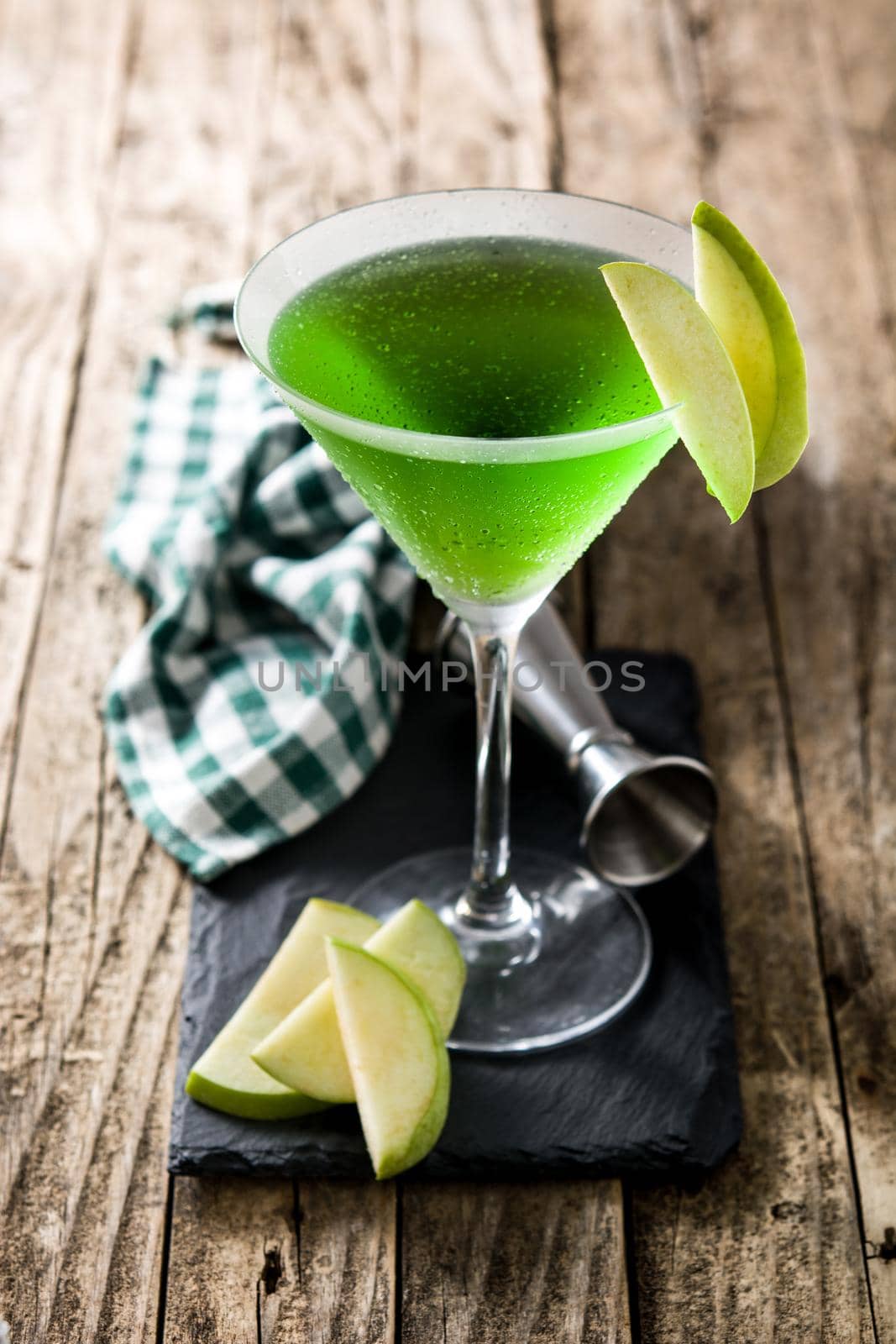 Green appletini cocktail on wooden table