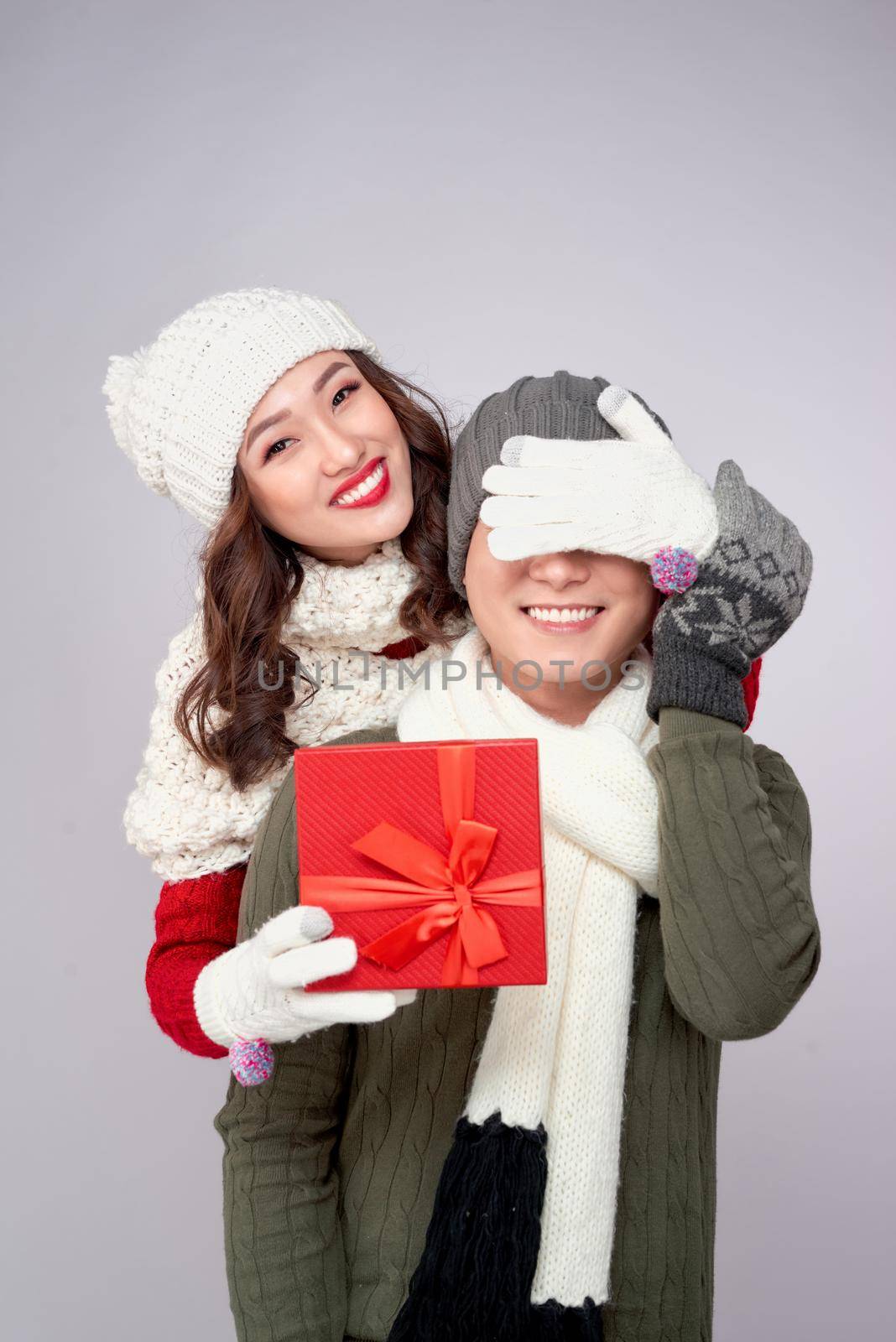 Couple gift. Young woman giving gift to boyfriend on white background