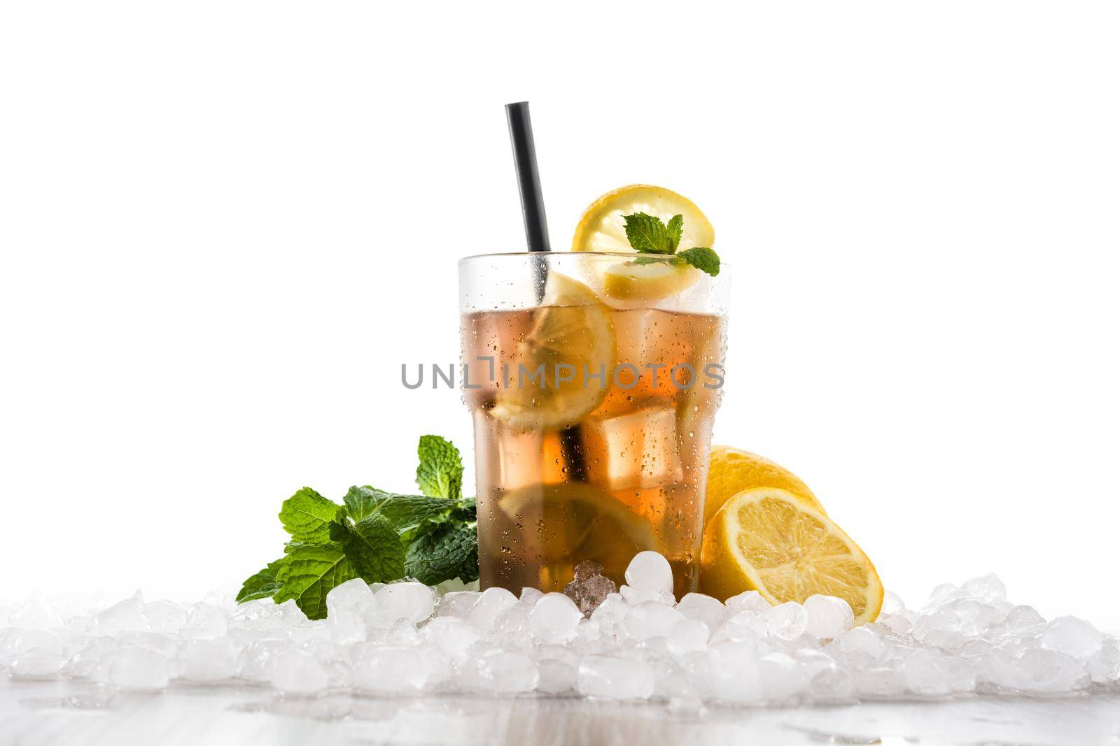 Iced tea drink with lemon in glass and ice on white wooden table