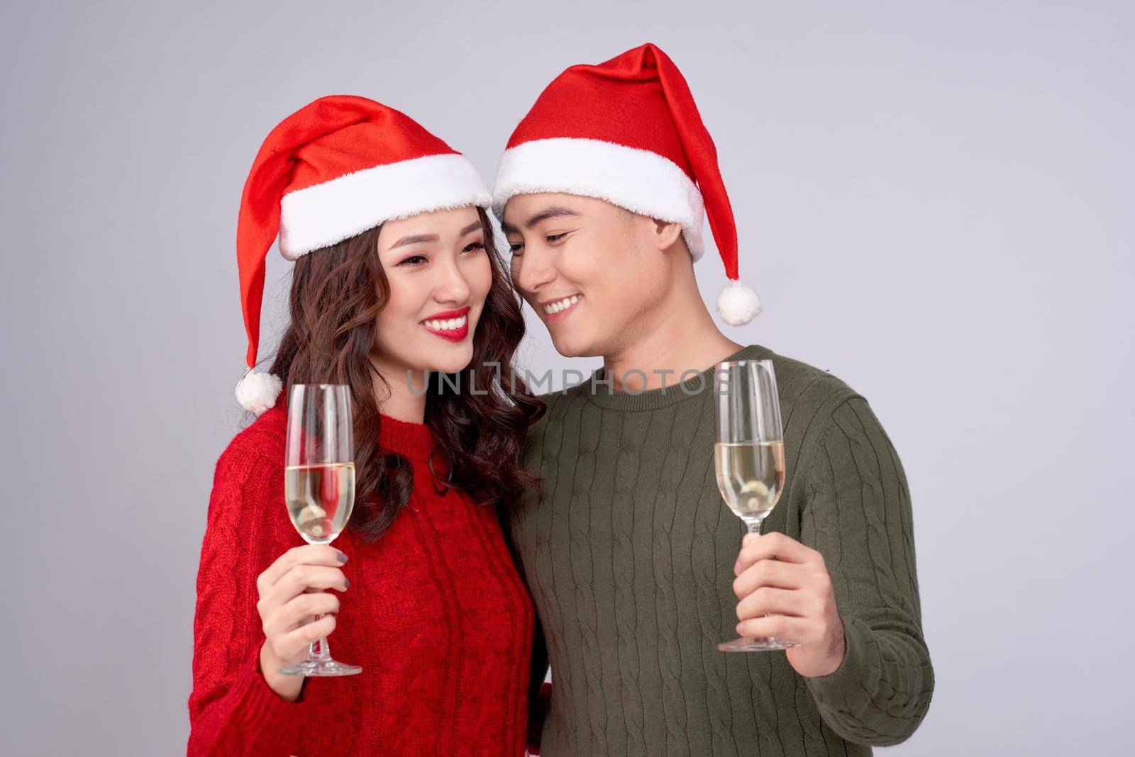 Asian couple wearing christmas hat and dress holding champagne glass