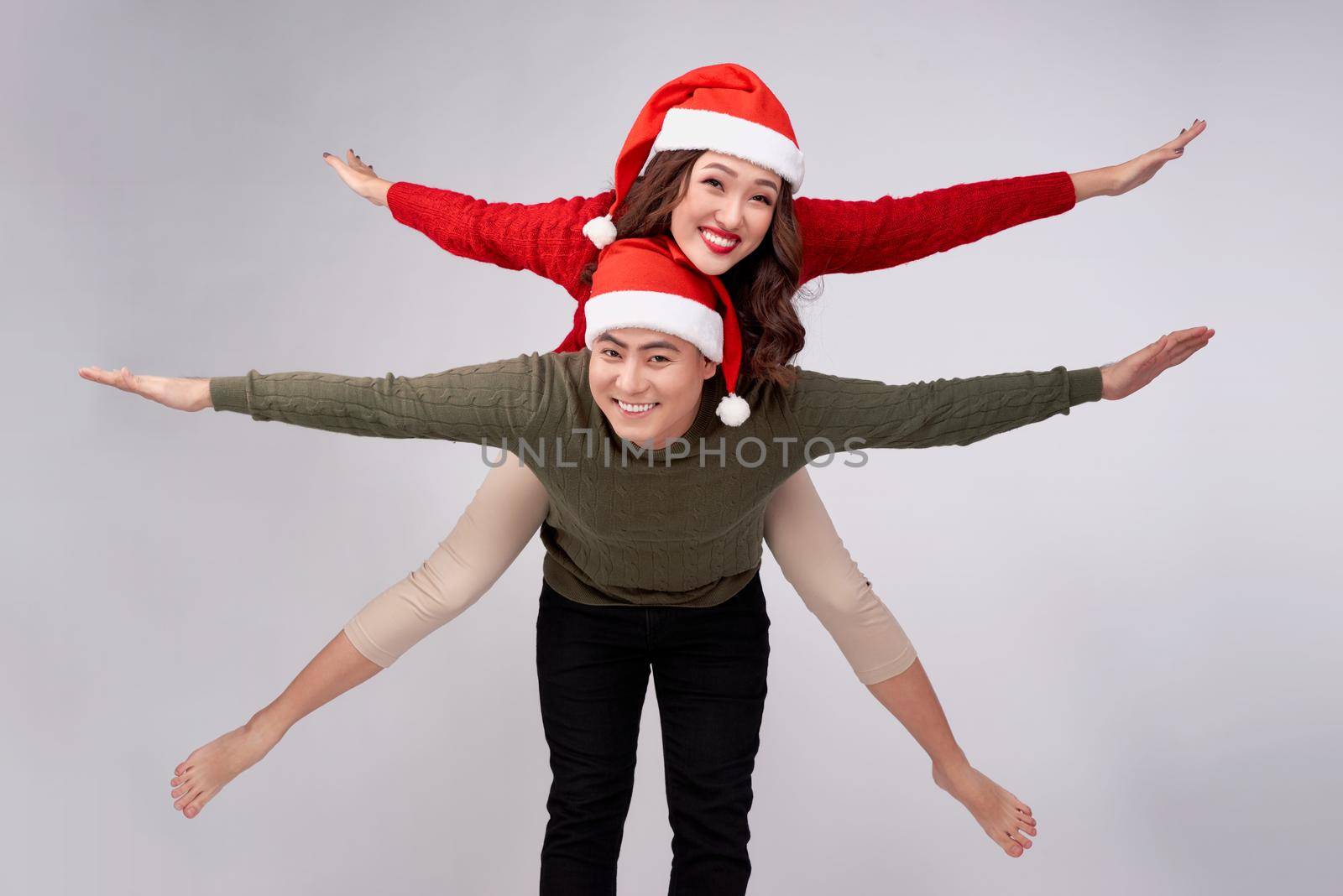 Beautiful love asian couple having piggybacking for Christmas holidays.