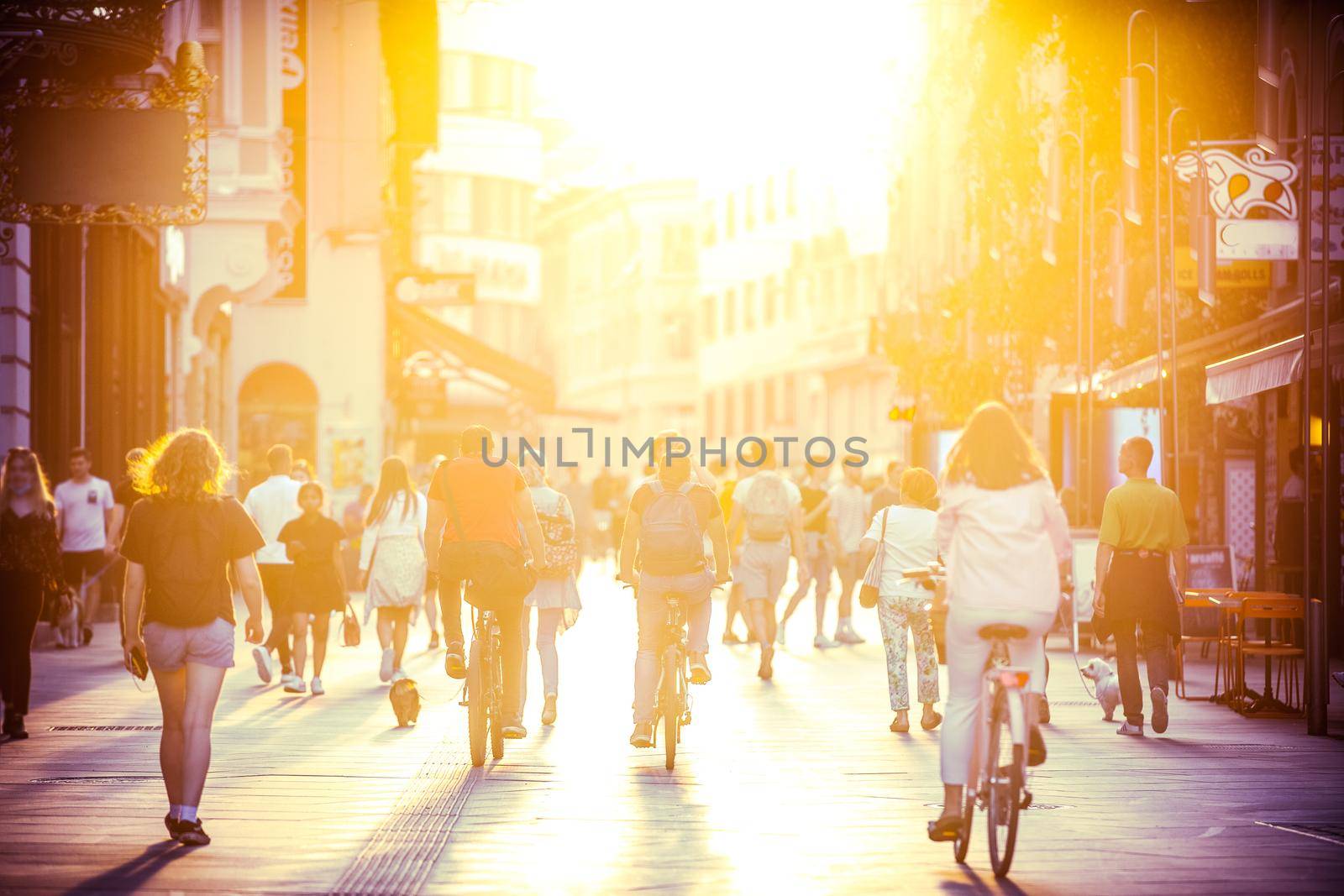 Blurred crowd of people on Copova pedestrian street in Ljubljana at sunset. Urban lifestyle and mobility concept