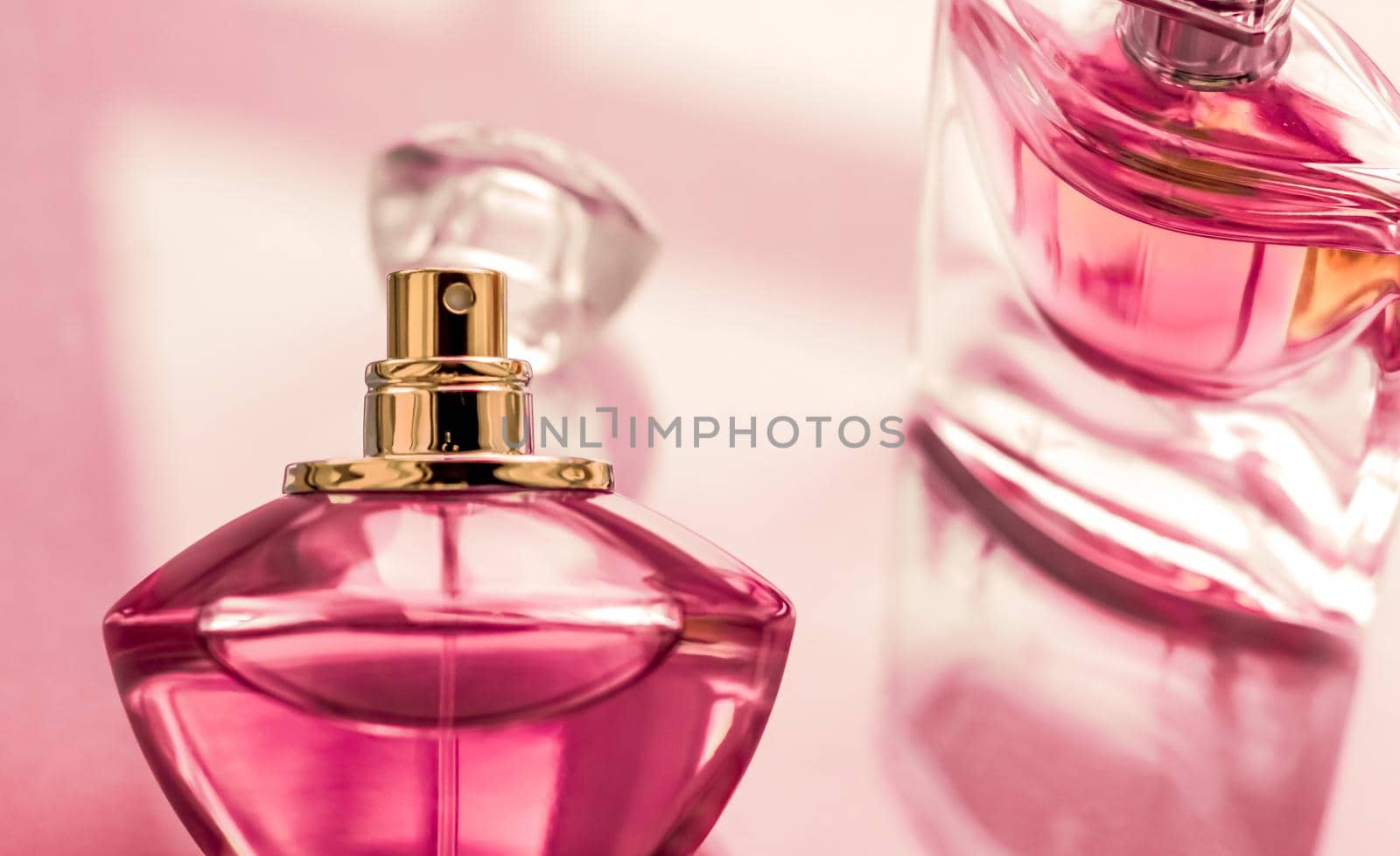 Perfumery, spa and branding concept - Pink perfume bottle on glossy background, sweet floral scent, glamour fragrance and eau de parfum as holiday gift and luxury beauty cosmetics brand design