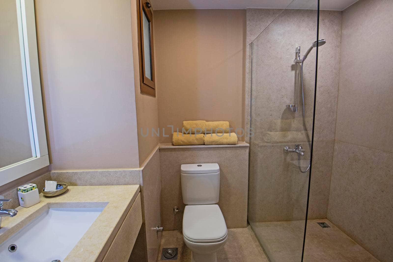 Interior design of a luxury show home bathroom with glass shower cubicle sink and toilet