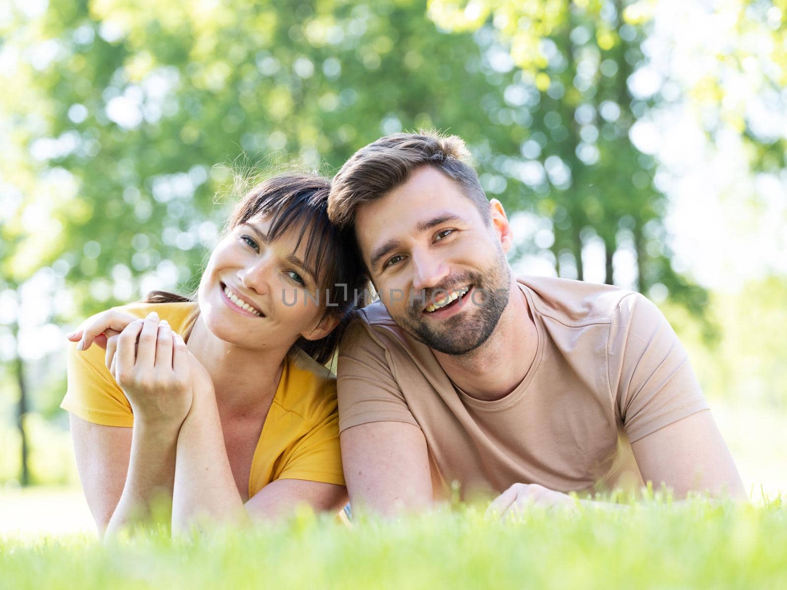 Couple lying outdoors smiling by ALotOfPeople
