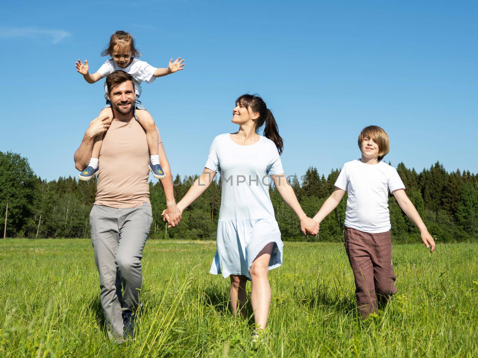 Family walking on summer meadow by ALotOfPeople