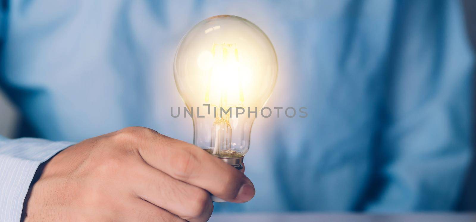Businessman holding light bulb, imagination and intelligence, innovation and inspiration, brain symbol and solution and knowledge, creative idea and success, business and marketing concept. by nnudoo