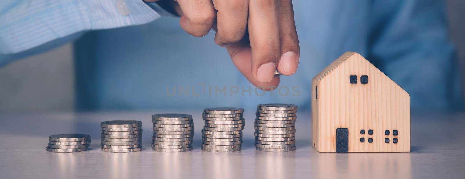 Hands of businessman and stack of coin with saving money for real estate and success, finance and investment, insurance home, deposit and property, residential and financial, business concept. by nnudoo