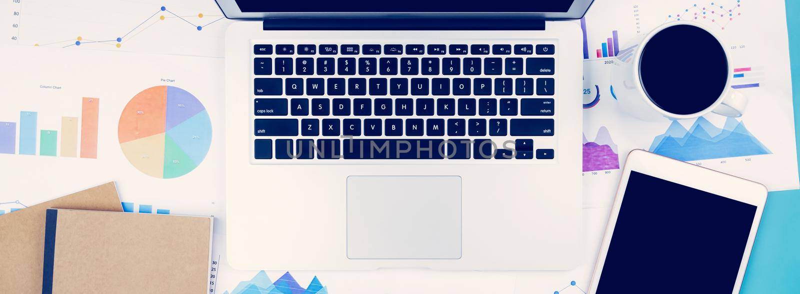 Laptop computer and documents report statistic financial with graph and chart and glasses and tablet, finance and invest, digital marketing and growth of revenue, business and communication concept. by nnudoo